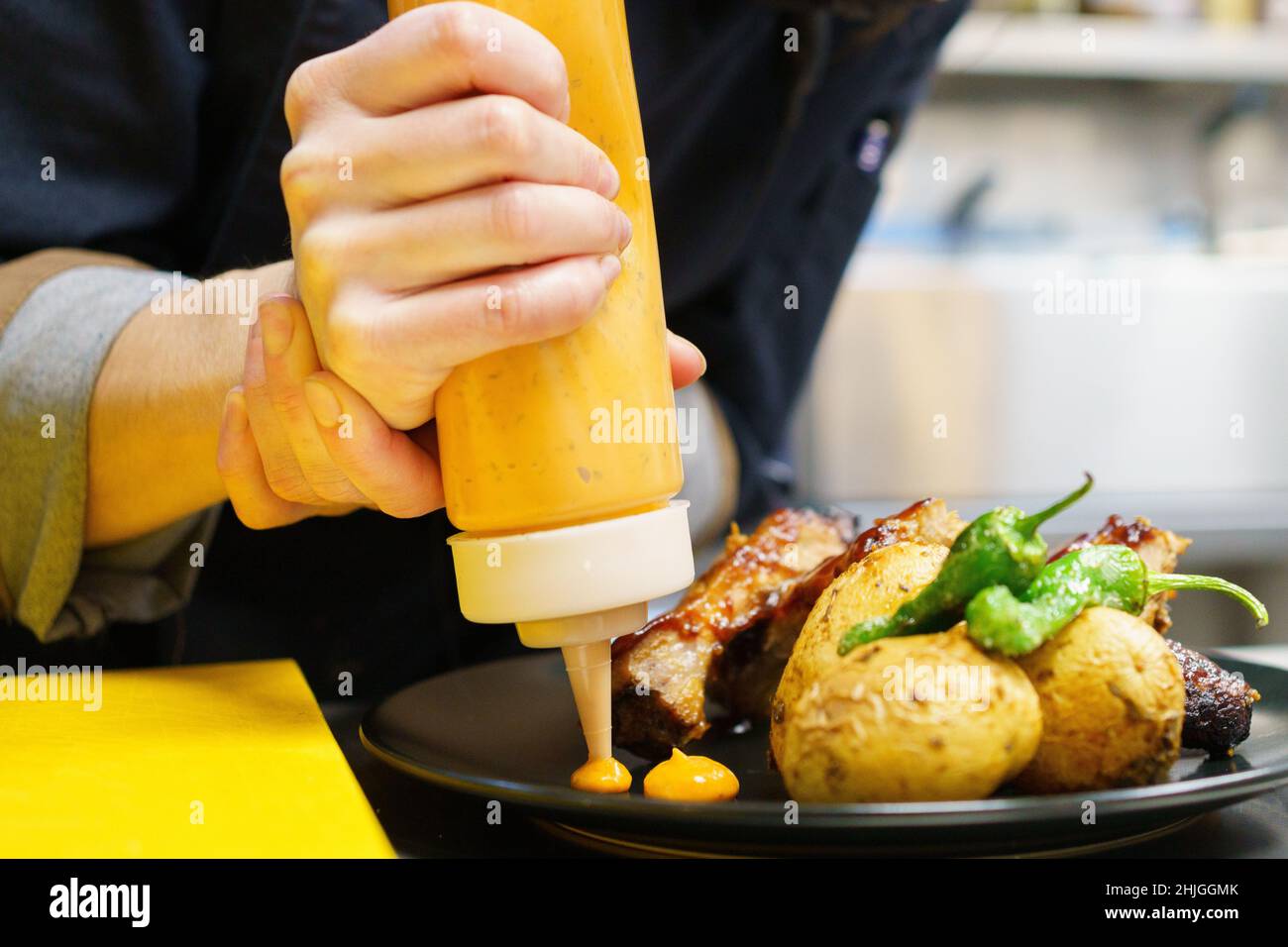 Anonymous chef plating roasted ribs with potatoes Stock Photo - Alamy