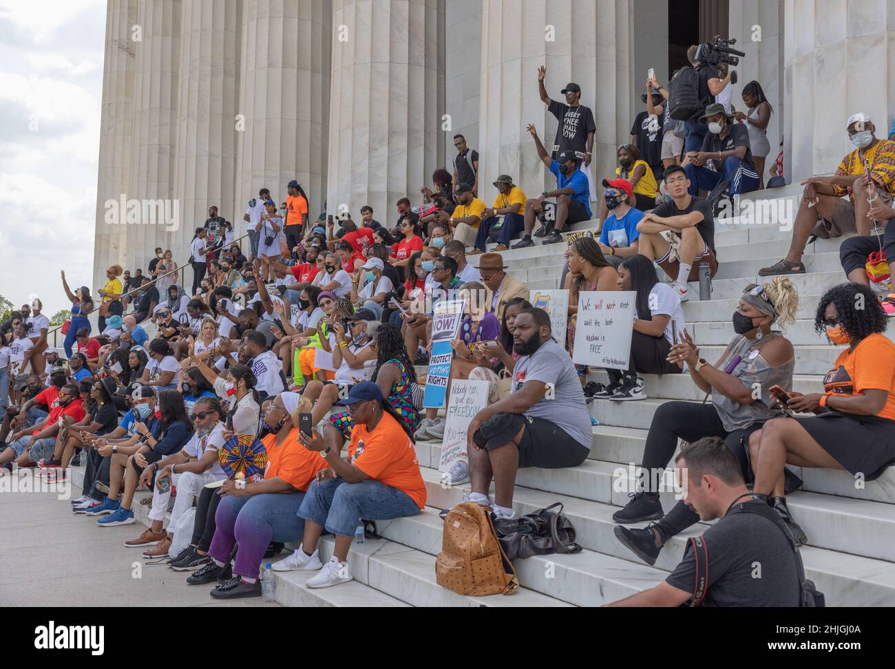 WASHINGTON, D.C. -- August 28, 2021: Demonstrators and others watch the ...