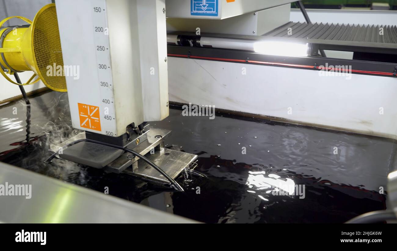 Metal cutting under water at factory. Scene. Processing of steel part