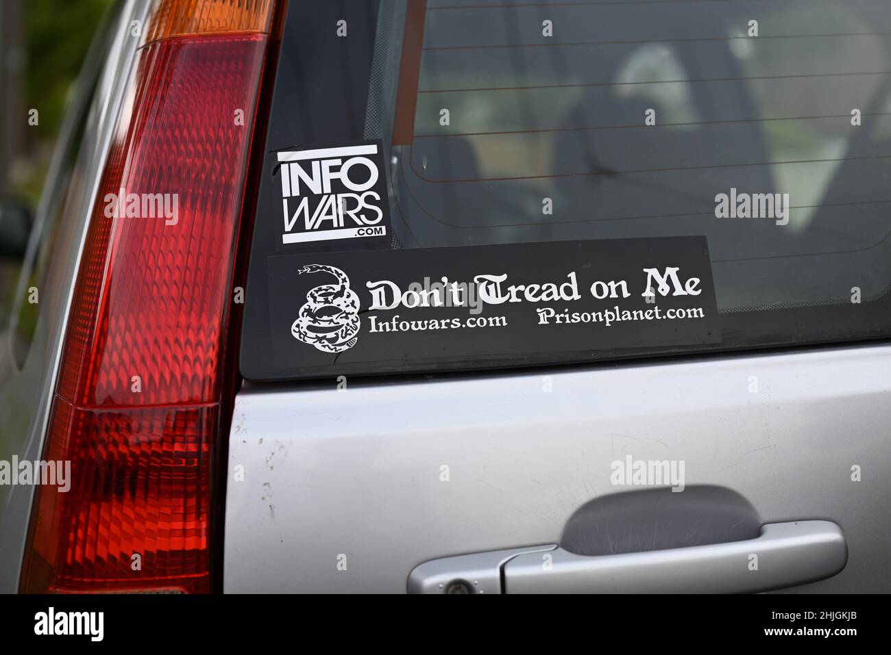 Two Info Wars stickers, with web addresses for infowars.com and prisonplanet.com, on the rear window of a silver vehicle Stock Photo