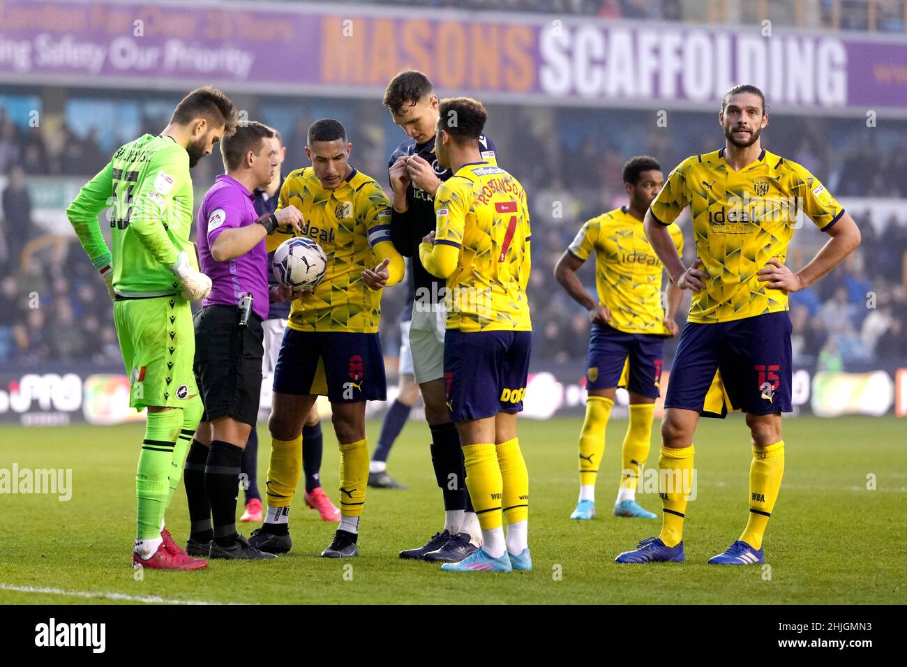 Referee Joshua Smith talks to West Bromwich Albion's Jake Livermore after flares had been thrown onto the pitch during the Sky Bet Championship match at The Den, Millwall. Picture date: Saturday January 29, 2022. Stock Photo