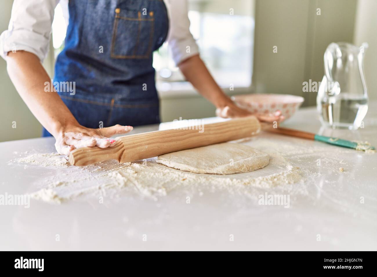 Young blonde woman kneading pizza dough at kitchen Stock Photo - Alamy