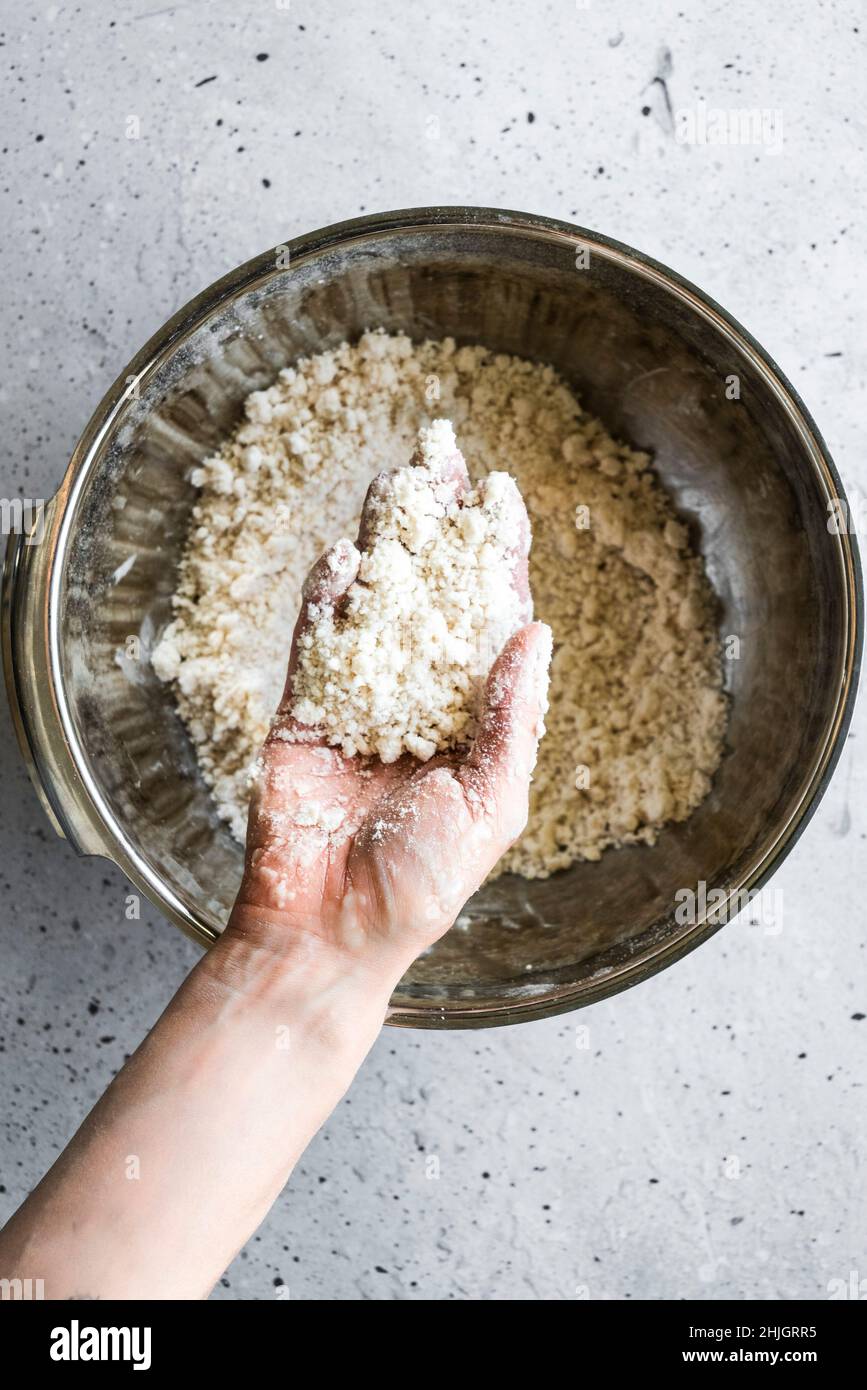 A baker making pie dough by hand Stock Photo