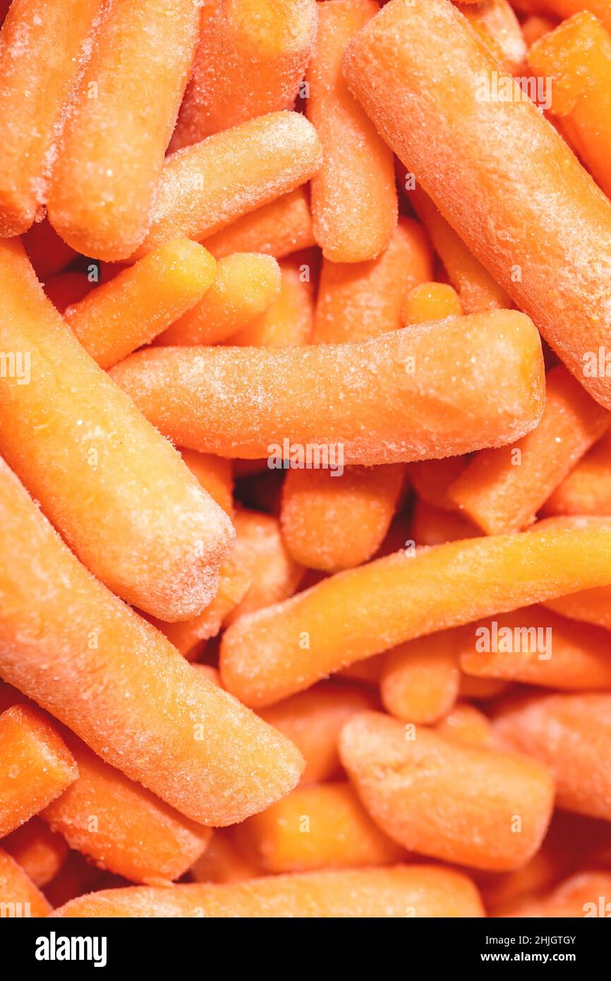 Heap of frozen peeled raw organic baby carrot. Food background, macro