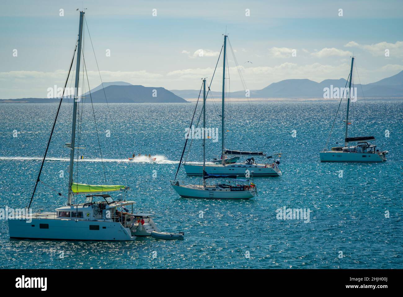 View of water skiing, sailboats and Fuerteventura in background, Playa Blanca, Lanzarote, Canary Islands, Spain, Atlantic, Europe Stock Photo