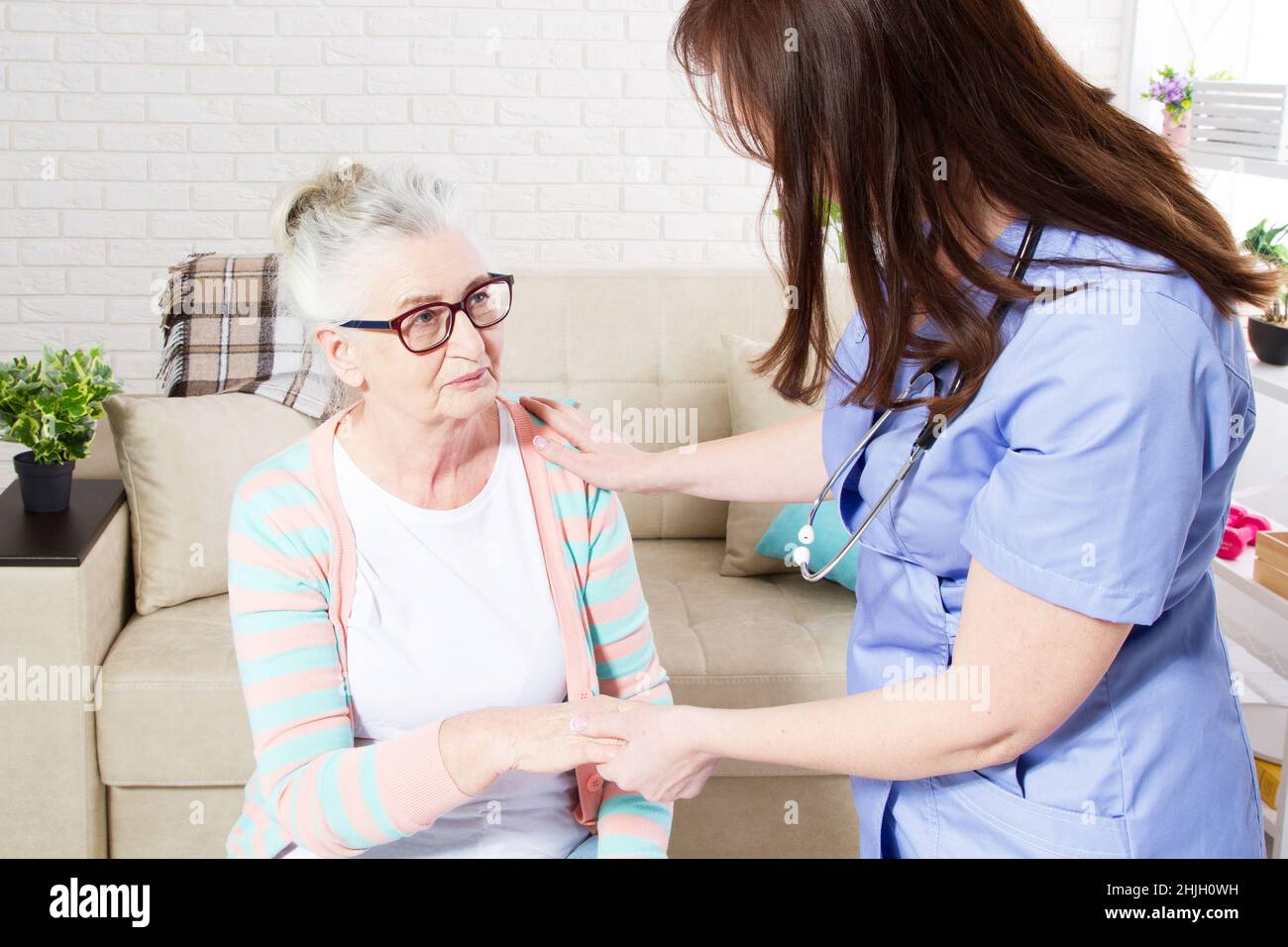 Close-up of elder woman training with physiotherapist, elderly woman with nurse at home Stock Photo