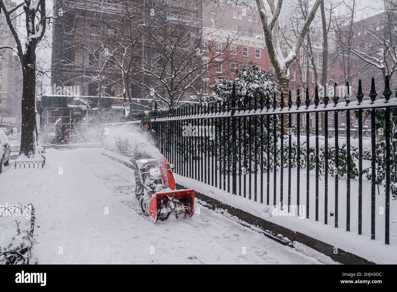 Digging out after a snow storm: a man using snow blower to clear sidewalk in Gramercy Park, New York City. Stock Photo
