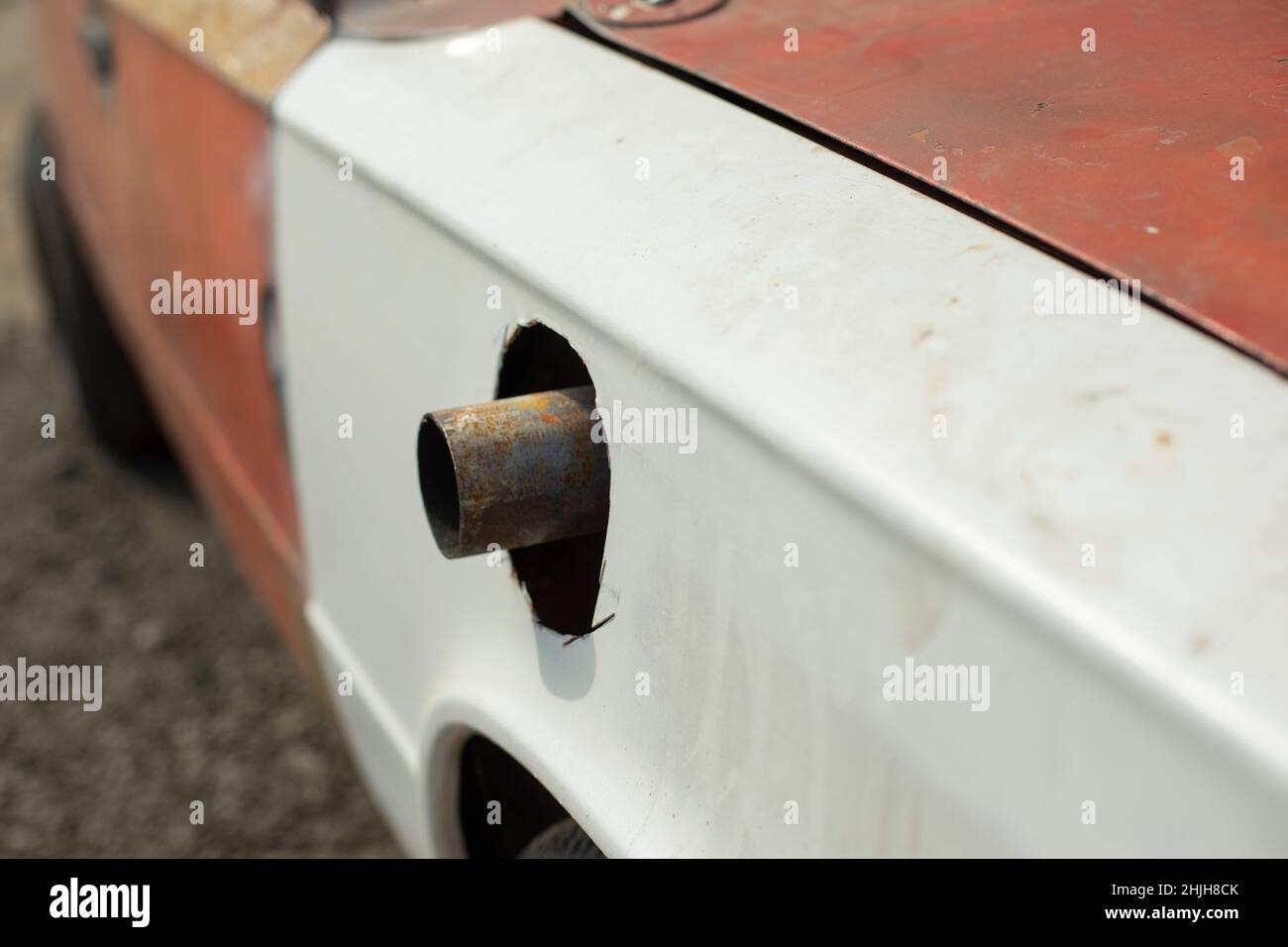Muffler pipe in race car. Cut hole for exhaust pipe in car. Modernized