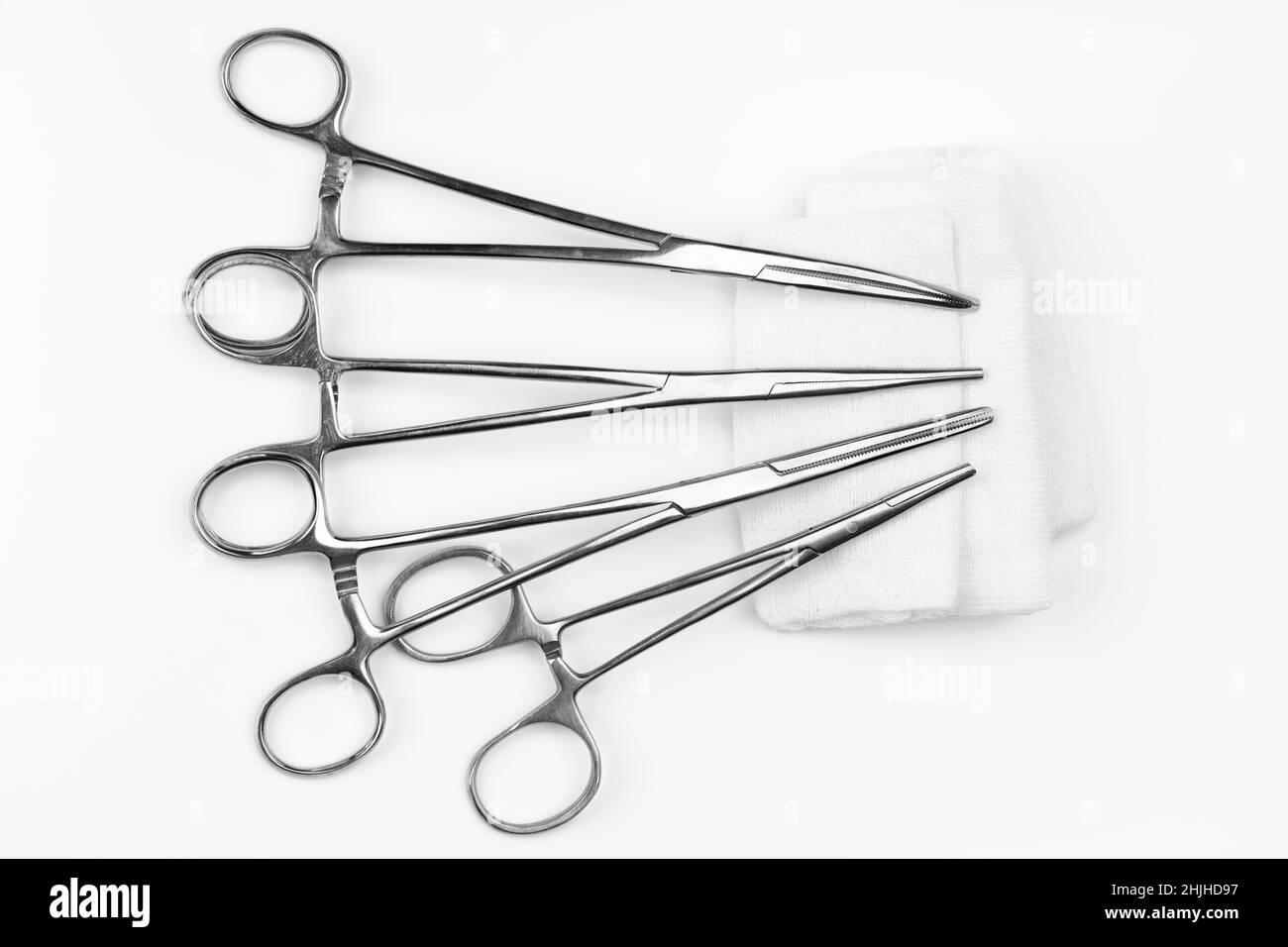 Lot of stainless surgical needle drivers lying on white sterile gauze swab. Medical instruments