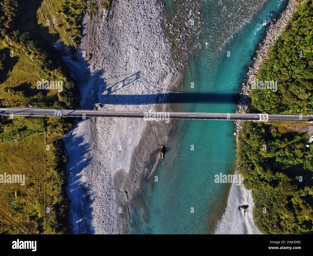 Aerial view of a long bridge over the river with mountains in the ...
