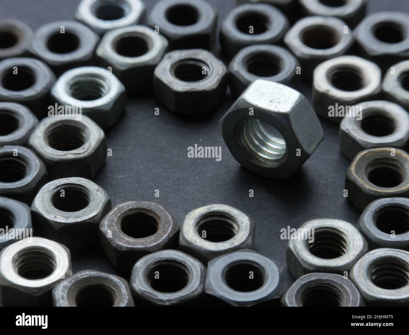 many steel iron nuts on grey table Stock Photo