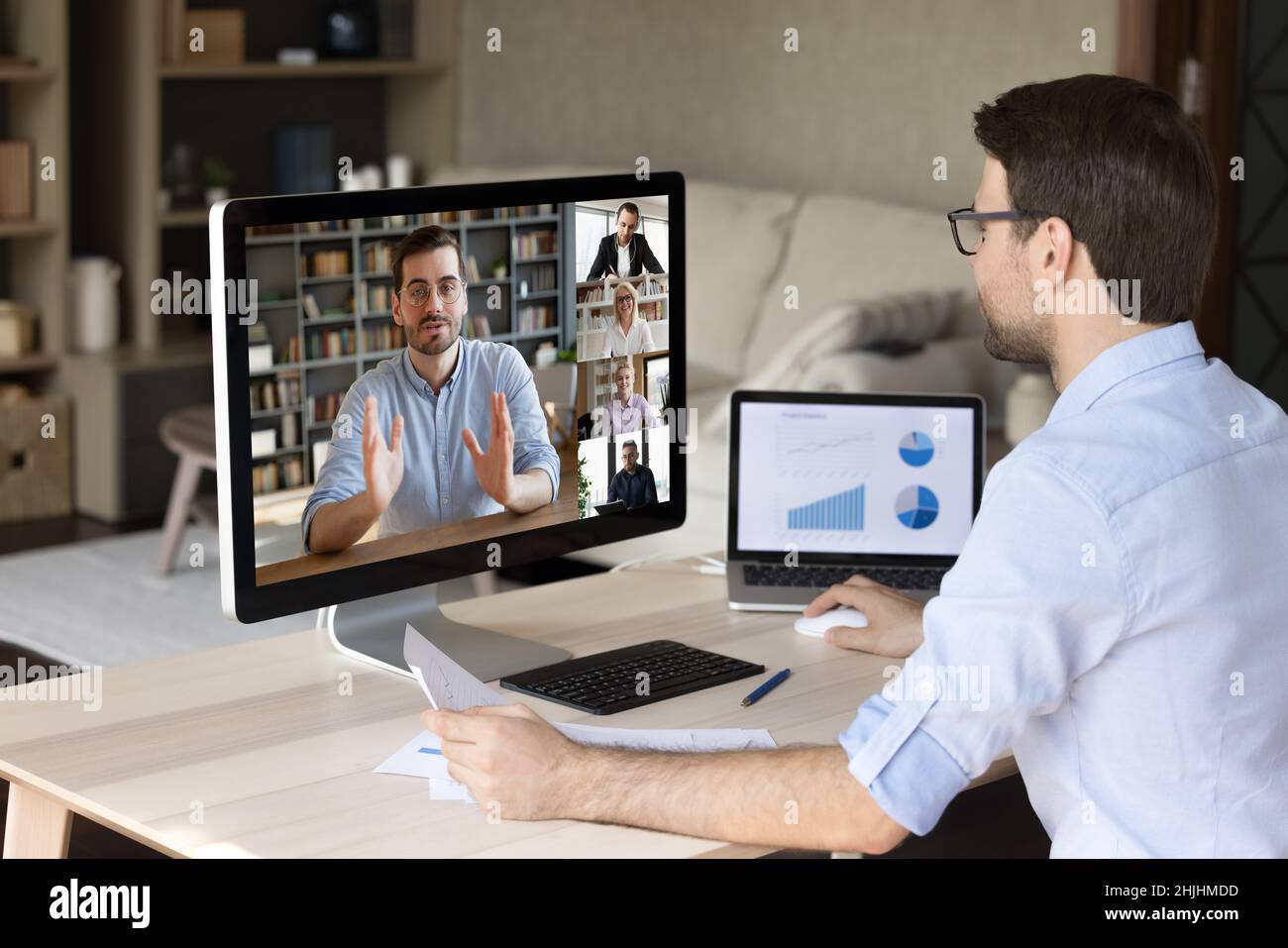 Smiling young employee working on different devices. Stock Photo