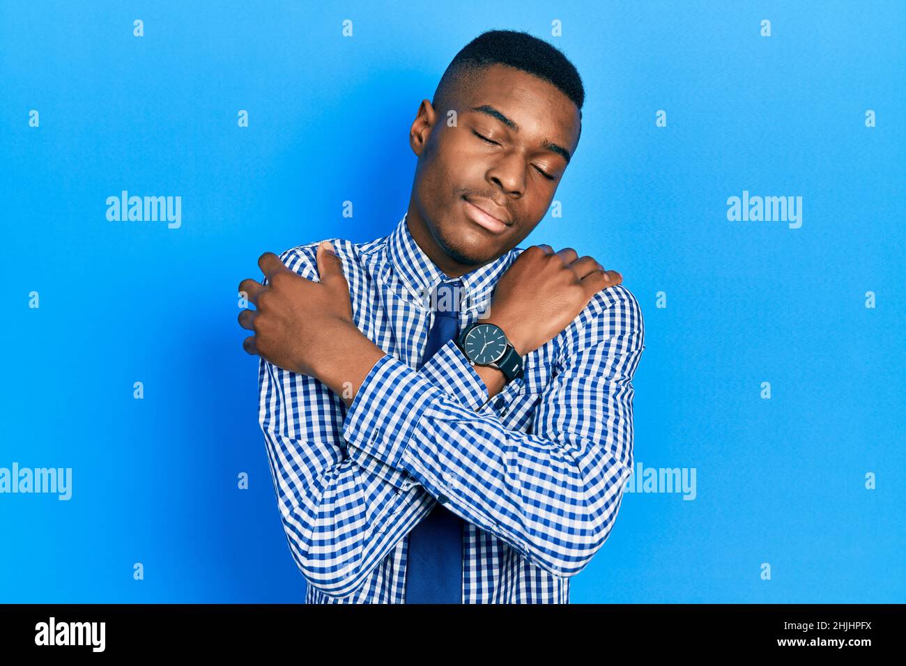 Young african american man wearing business shirt and tie hugging ...