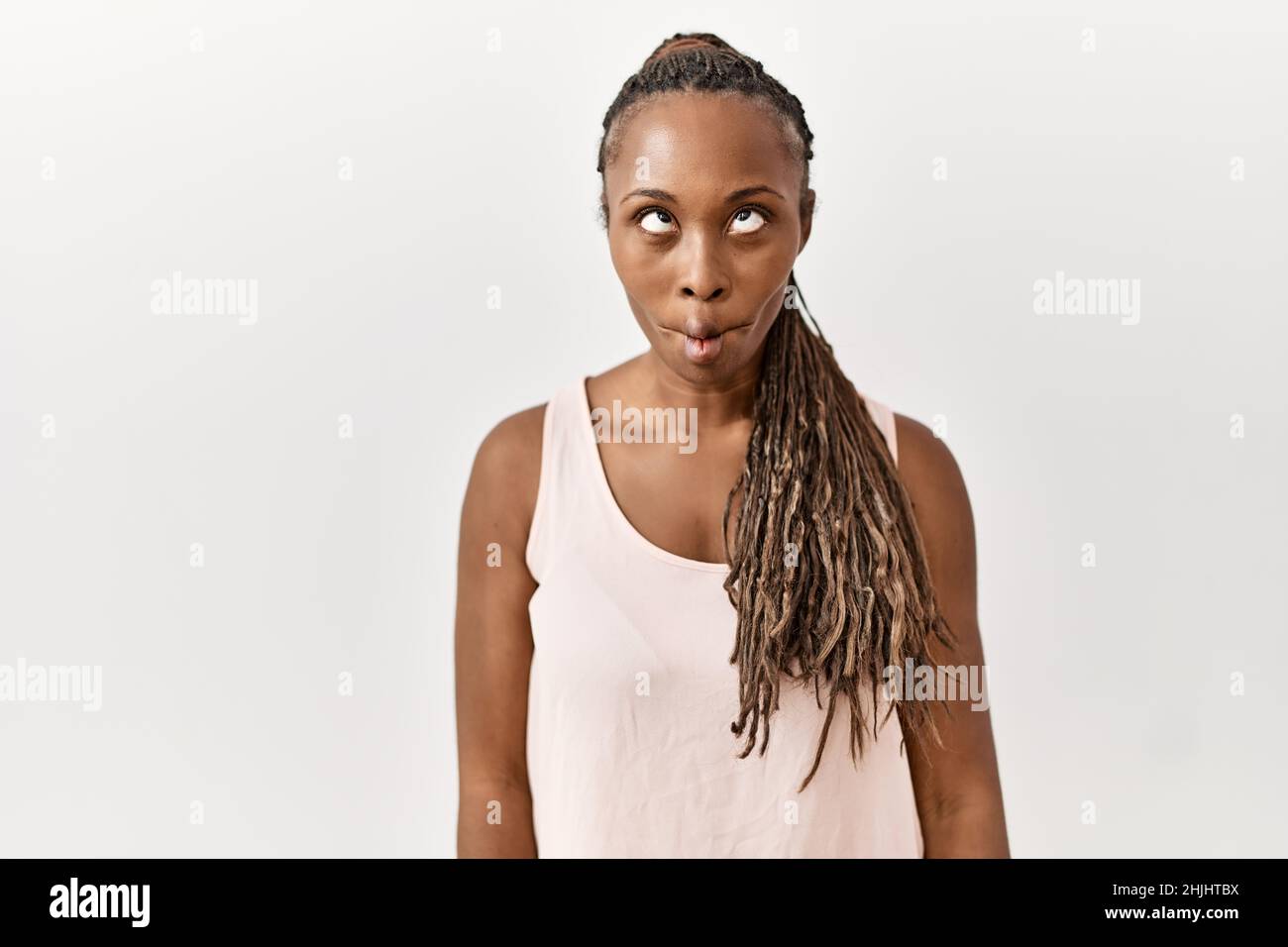 Black woman with braids standing over isolated background making fish face  with lips, crazy and comical gesture. funny expression Stock Photo - Alamy