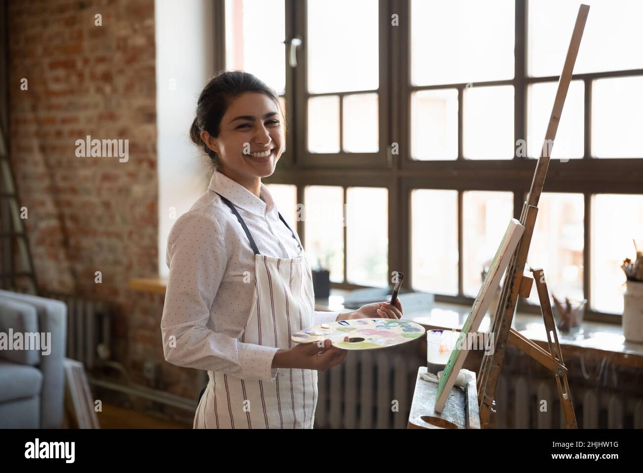 Happy inspired young Indian artist woman enjoying hobby Stock Photo