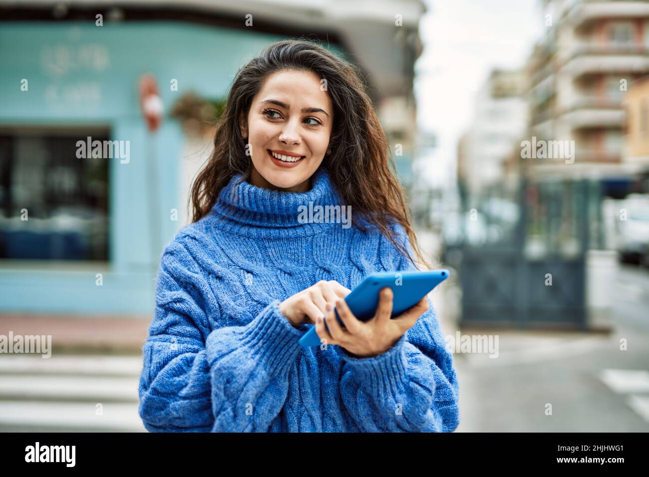 Young hispanic woman smiling happy using touchpad at the city Stock ...