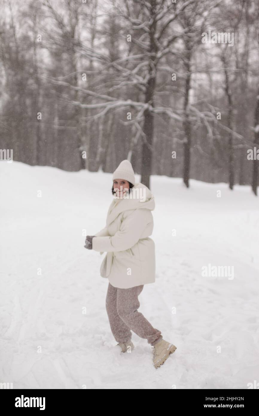 Two girls playing snowballs in the snow in the winter in a warm winter clothes Stock Photo