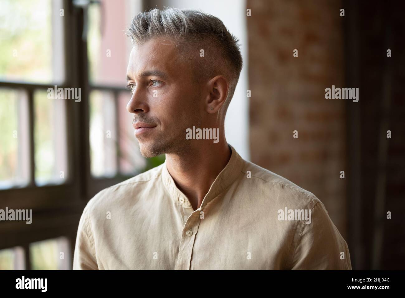 Serious thoughtful handsome millennial grey haired business man head shot Stock Photo