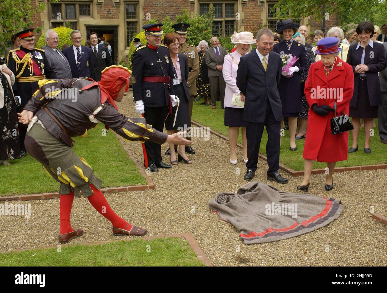 File photo dated 9/5/2002 of Queen Elizabeth II being invited to step on a cape thrown at her feet by an 'Elizabethan fool', alias Peet Cooper, at Eastbury Manor House during her Golden Jubilee visit to East London. Issue date: Sunday January 30, 2022. Stock Photo