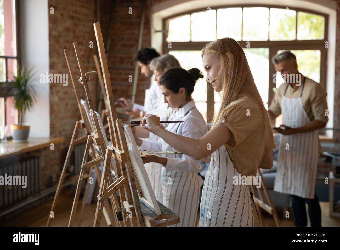 Multiethnic group of art school students drawing in paints Stock Photo