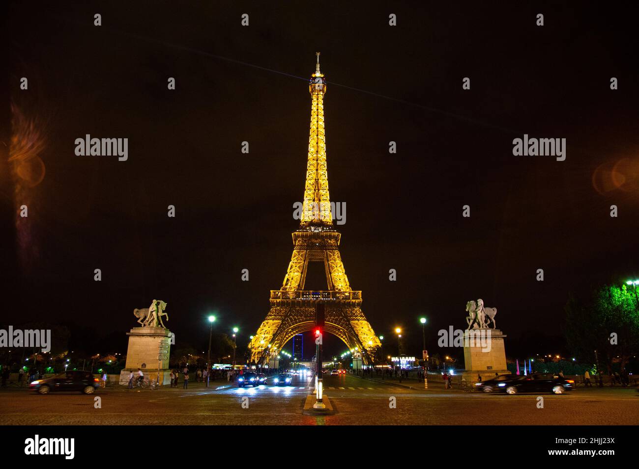 The eiffel tower lit up at night over looking the city Stock Photo - Alamy