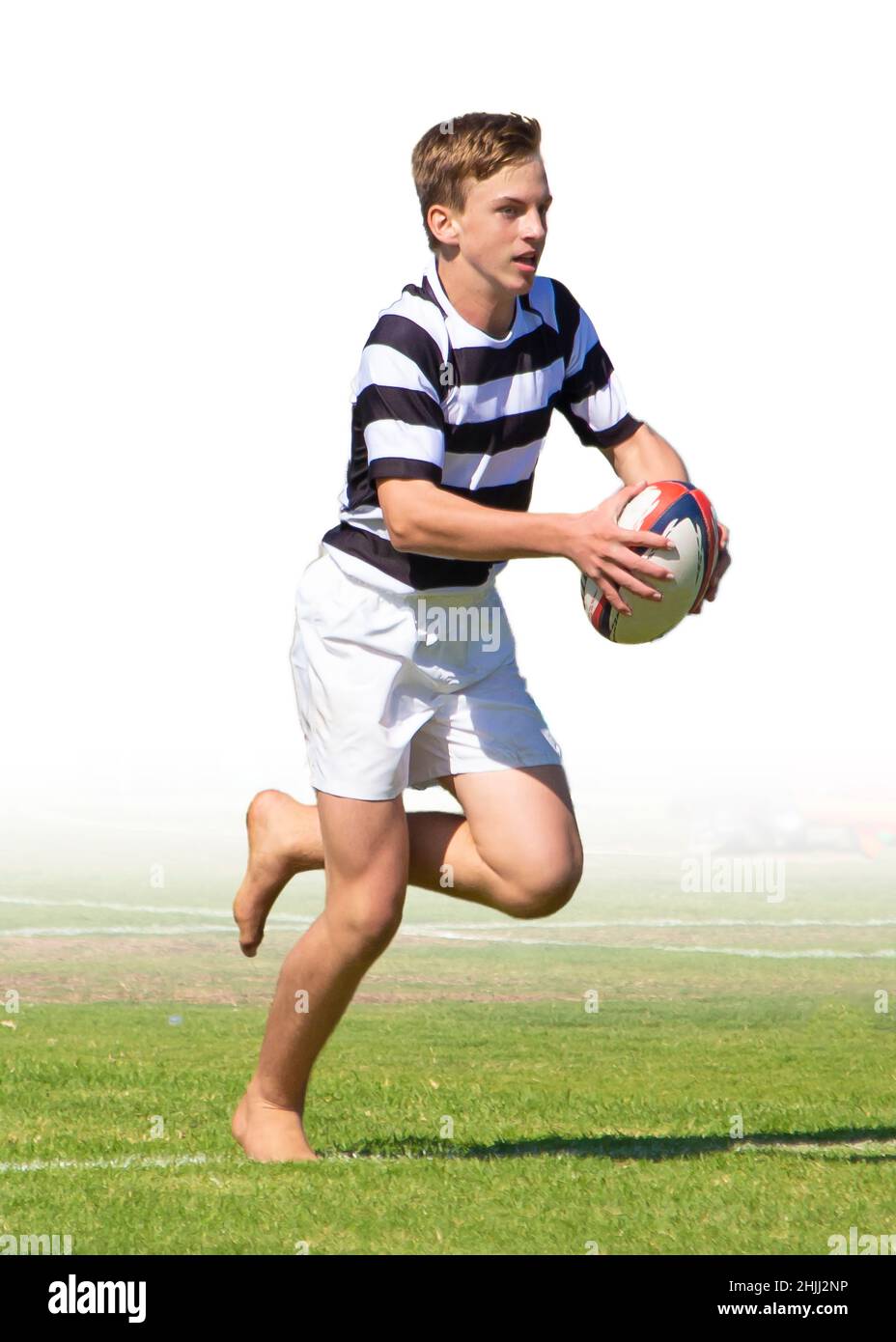 A teenage boy carrying the rugby ball in a match for a school rugby team. Stock Photo