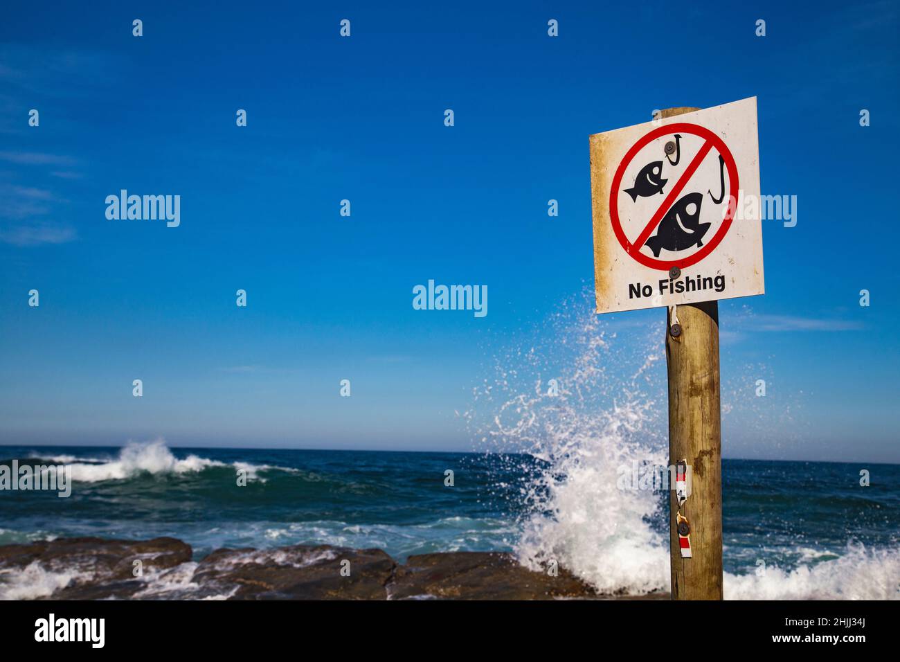 No fishing sign on a rocky outcrop in the sea. Stock Photo