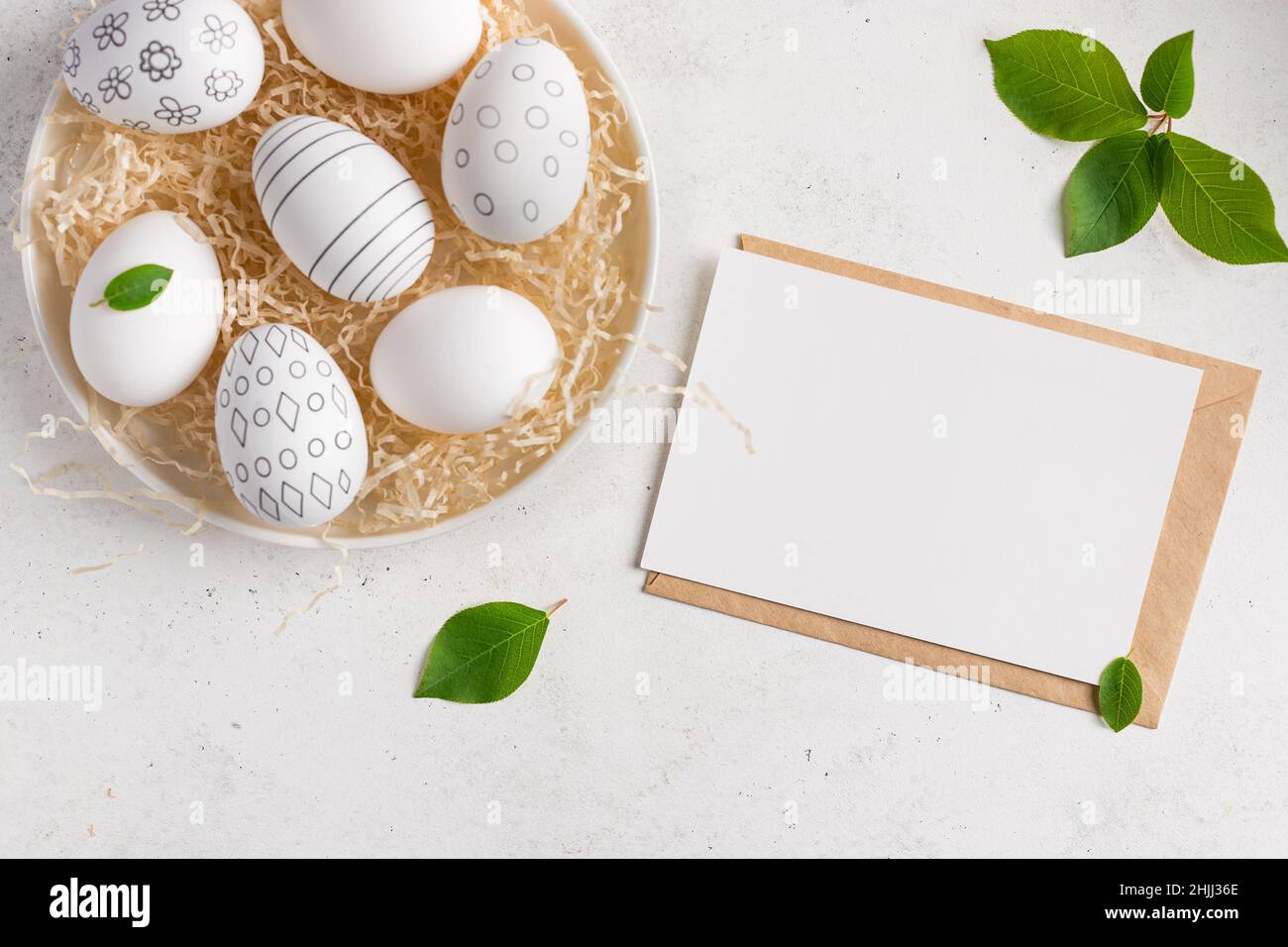 Easter composition with blank paper card and easter eggs Stock Photo