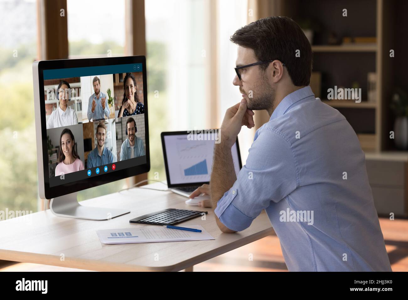 Concentrated millennial manager holding video call with colleagues. Stock Photo