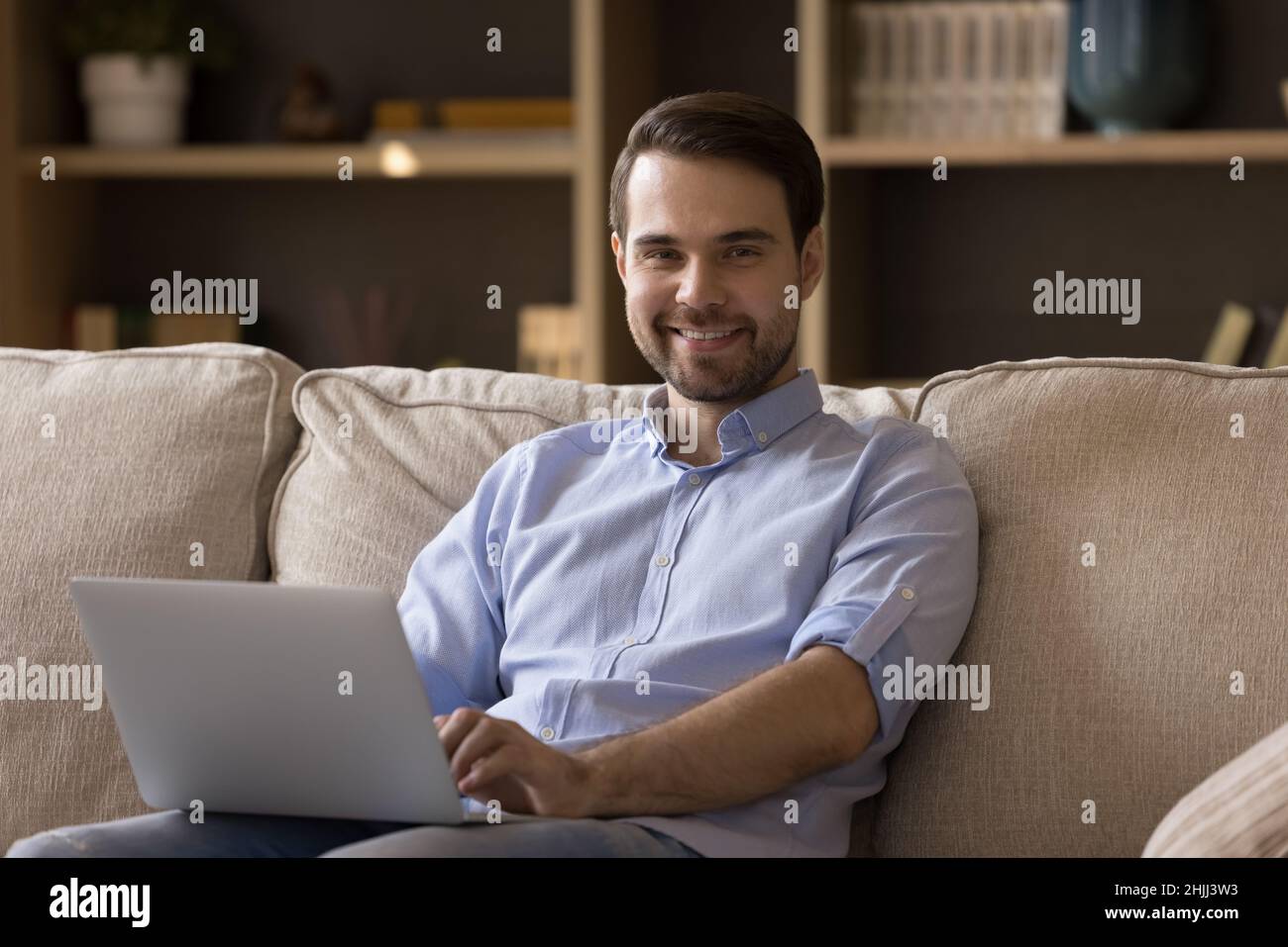 Portrait of handsome young man using computer at home. Stock Photo