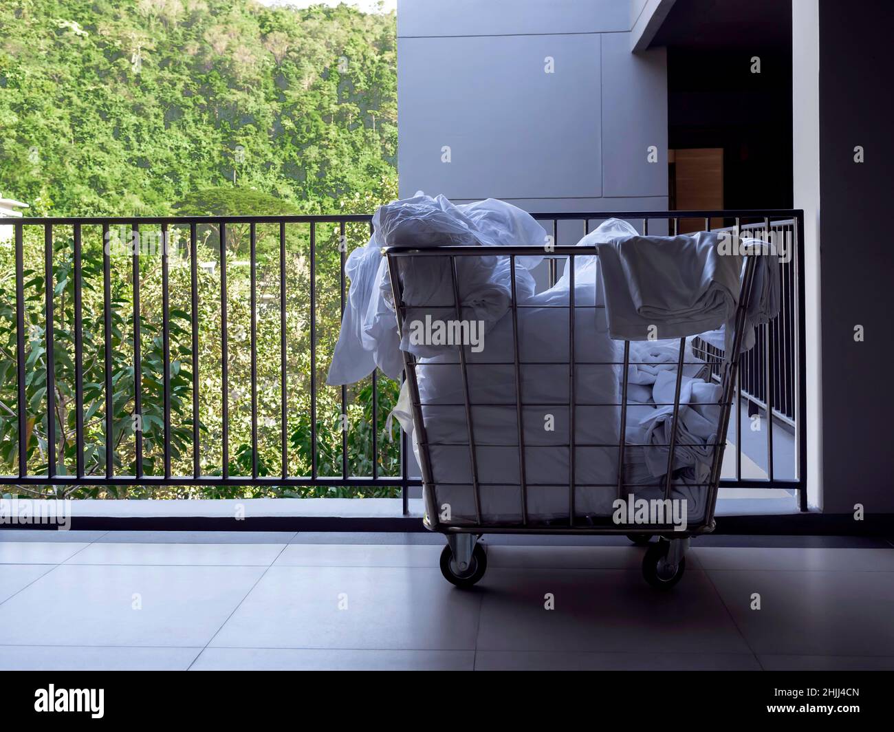 Hotel housekeeping maid laundry trolley with white used bed sheets