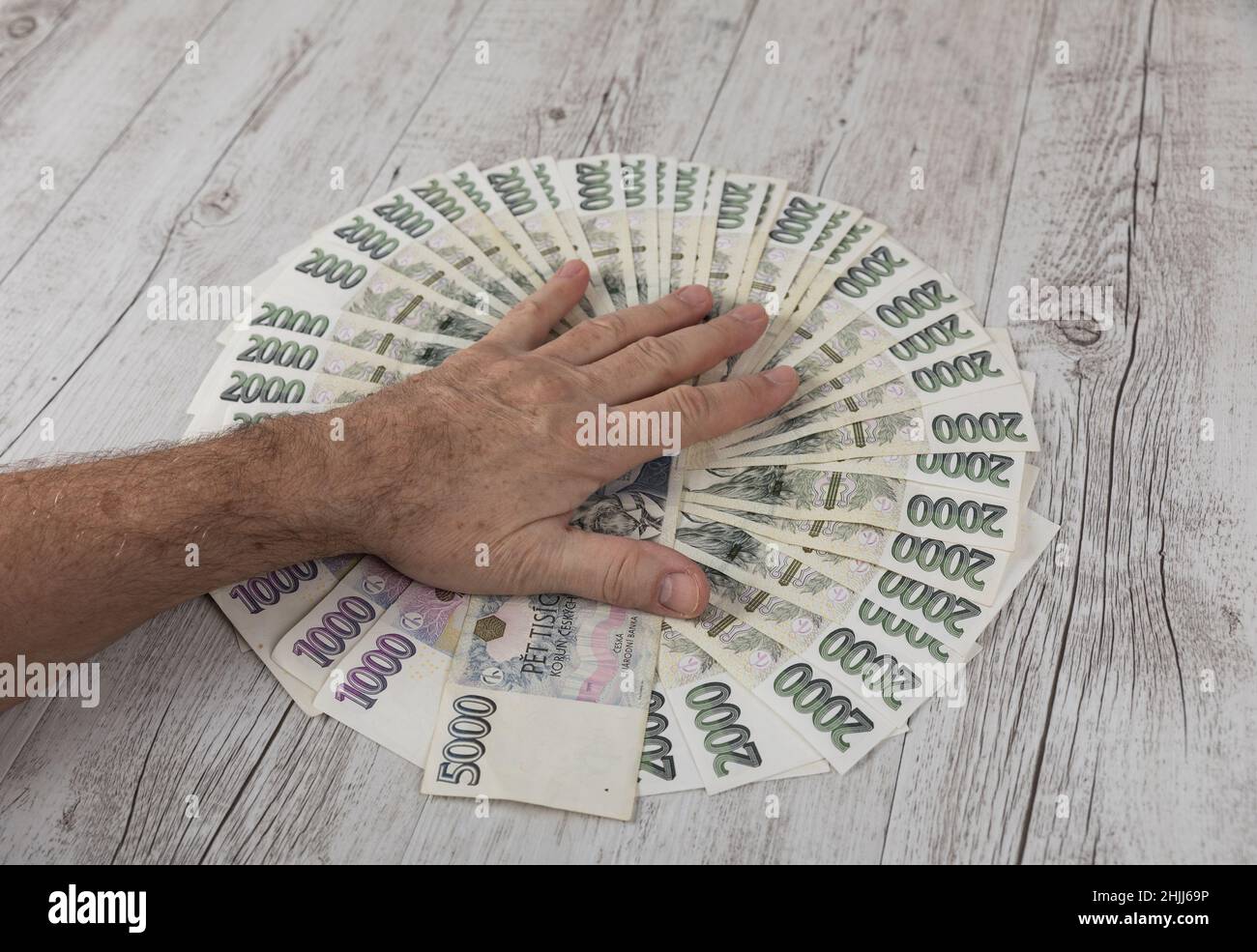 Czech banknotes in a fan and the hands of a merchant placed on them. Financial concept.Financial concept in Czech currency. business, finance, saving Stock Photo