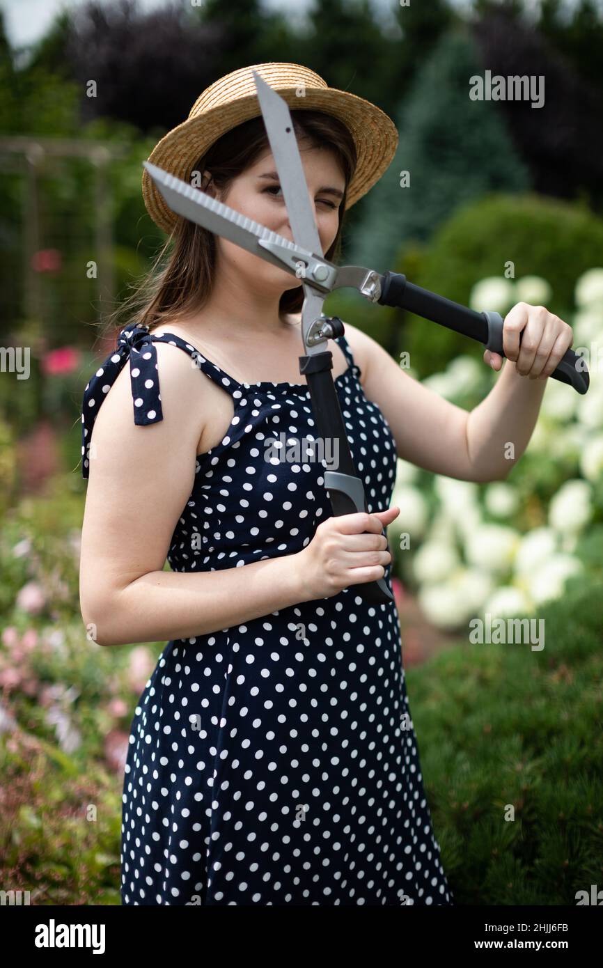 A young lady gardener shows off a large garden shears Stock Photo - Alamy