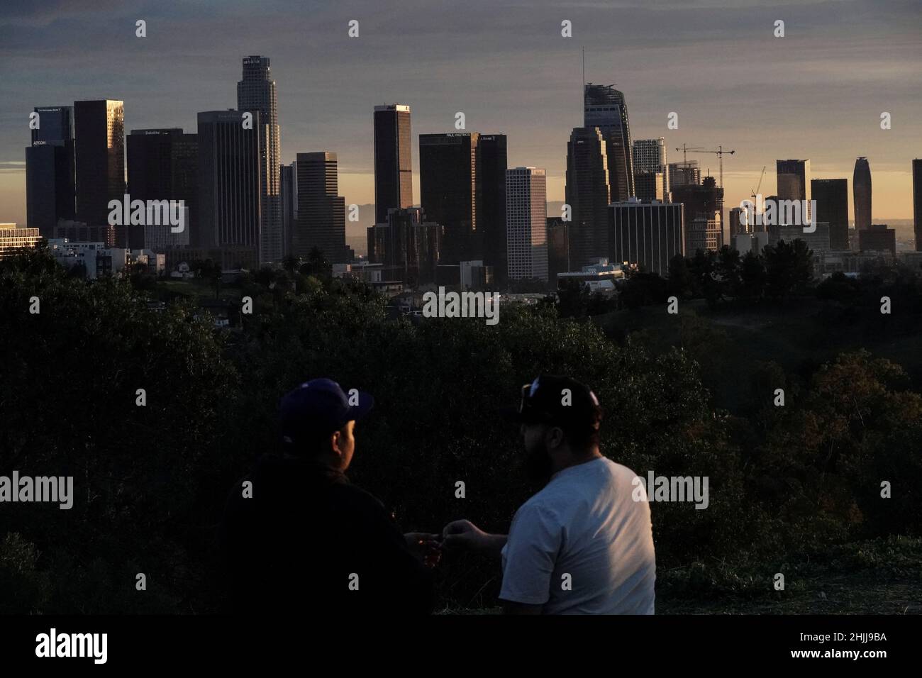Two people smoke marijuana while looking at the downtown L.A. skyline, ahead of Super Bowl LVI, during sunset at Angels Point, Elysian Park in Los Angeles, California, U.S., January 29, 2022.  REUTERS/Bing Guan Stock Photo