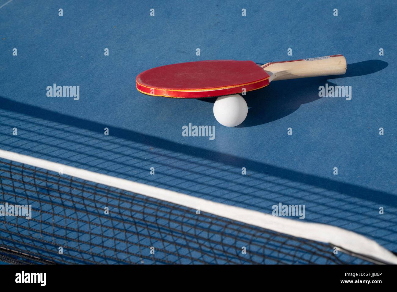Ping pong racquet, ball and net Stock Photo