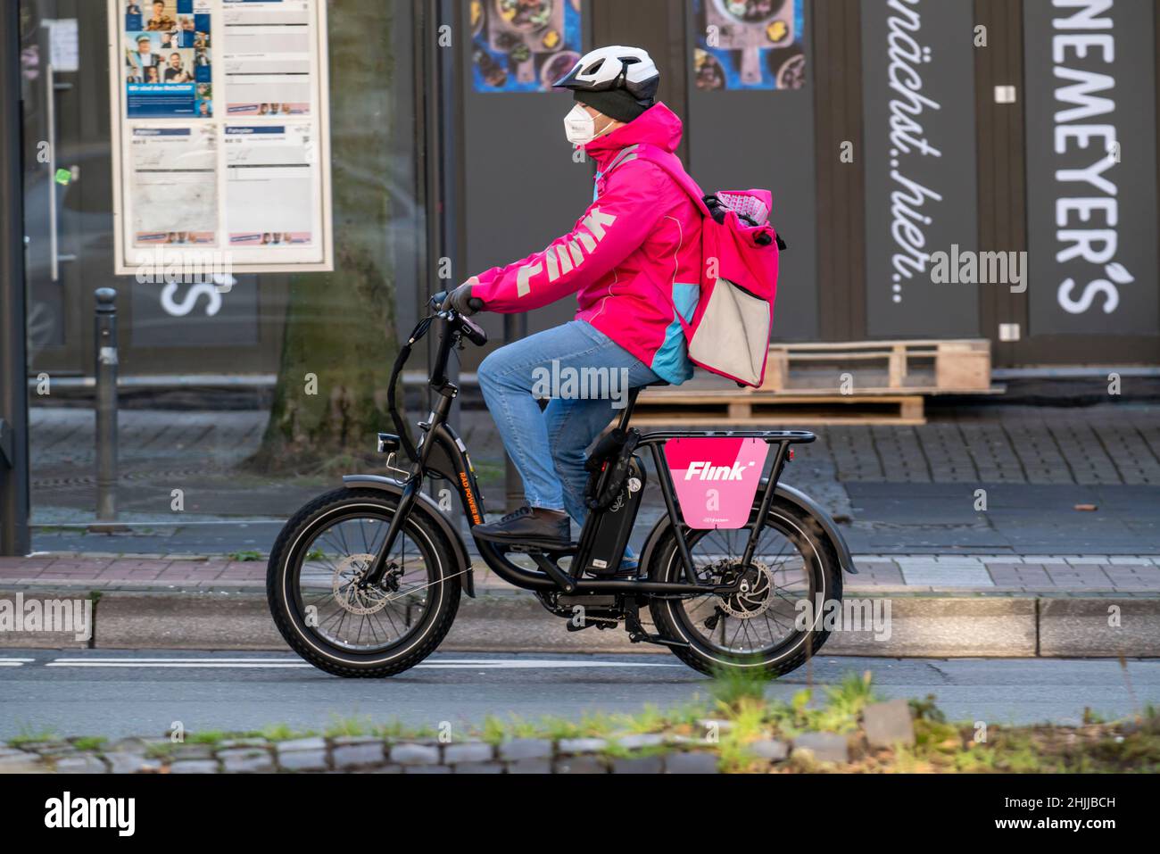 Bicycle courier of the fast delivery service Flink, delivers groceries, in currently over 40 German cities, within 10 minutes, orders via an app, work Stock Photo