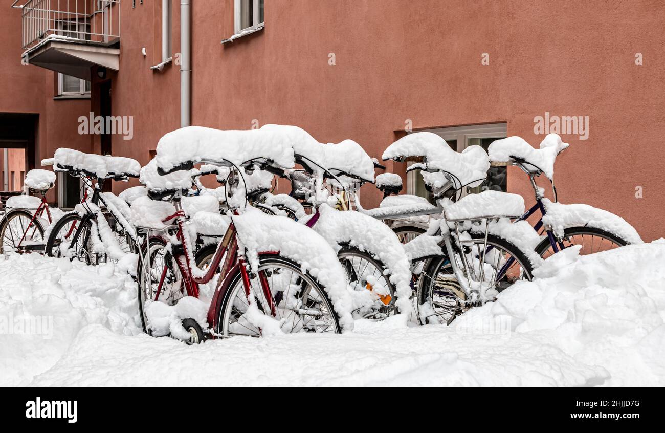 Snow-covered bicycles parked in the courtyard of a residential building in Vilhonvuori, Helsinki, Finland. Stock Photo