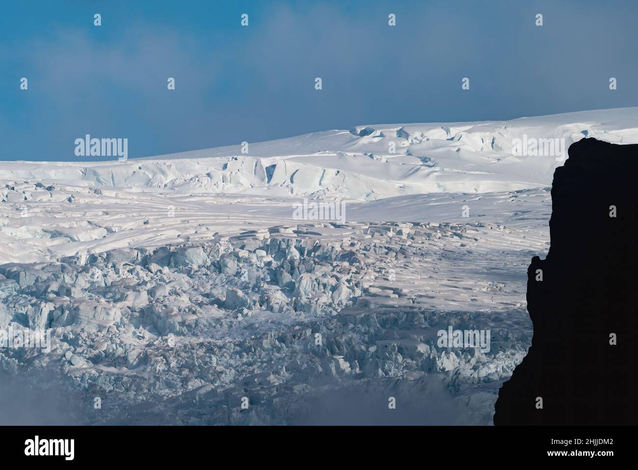 Glaciar, blue sky and dark mountain profile Stock Photo