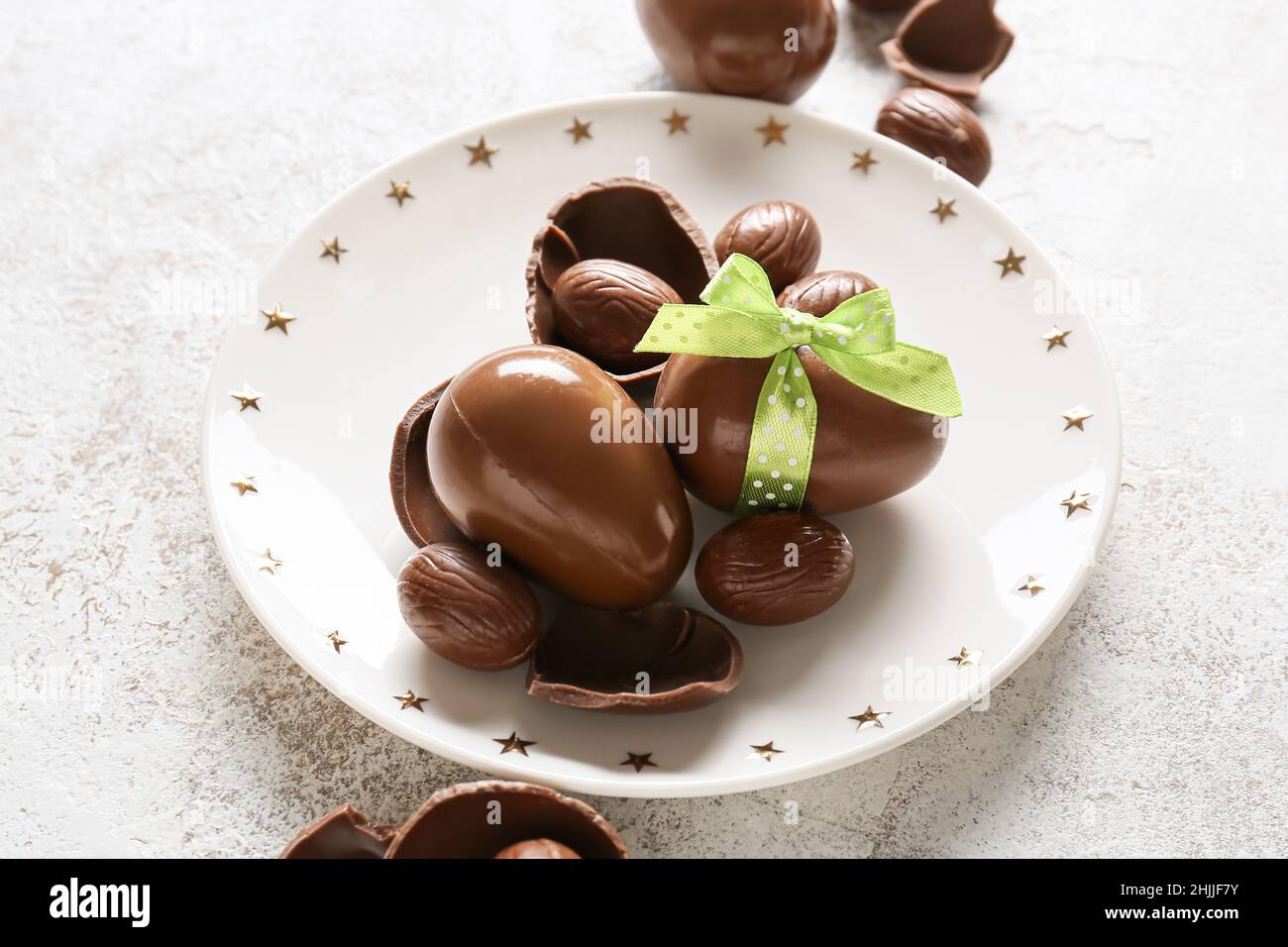 Plate with chocolate Easter eggs on light background Stock Photo