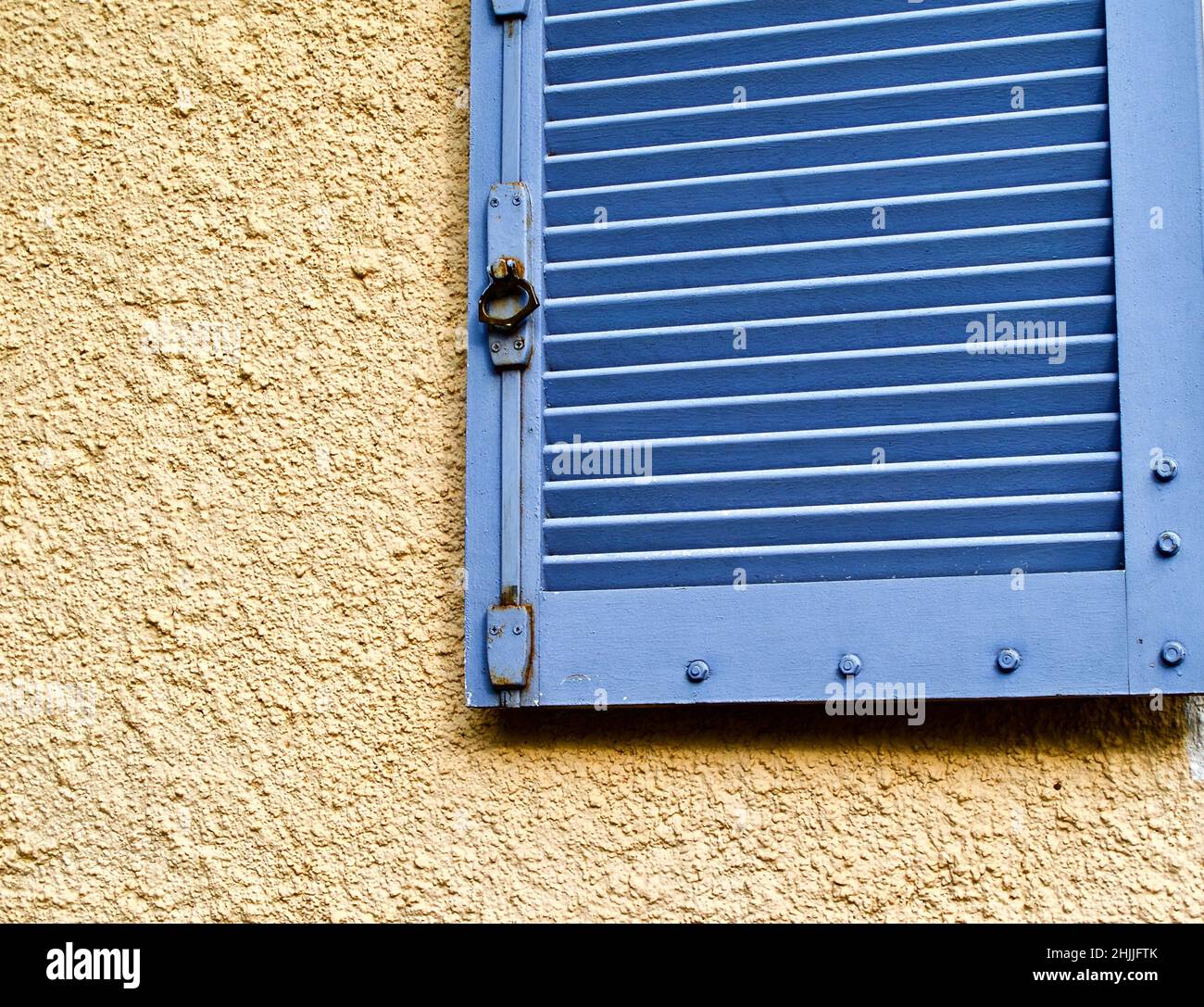 Yellow stone wall with blue wooden window shutter in France Stock Photo ...