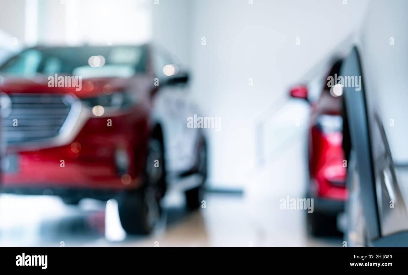 Blur new red car parked in luxury showroom. Car dealership office. New car parked in modern showroom for sale and rental service. Automobile leasing Stock Photo