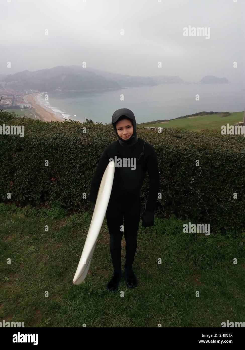 Spanish boy in wetsuit ready to surf Stock Photo Alamy