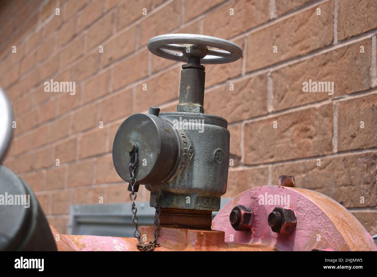 Closeup shot of a gate valve stuck on a brick wall Stock Photo Alamy