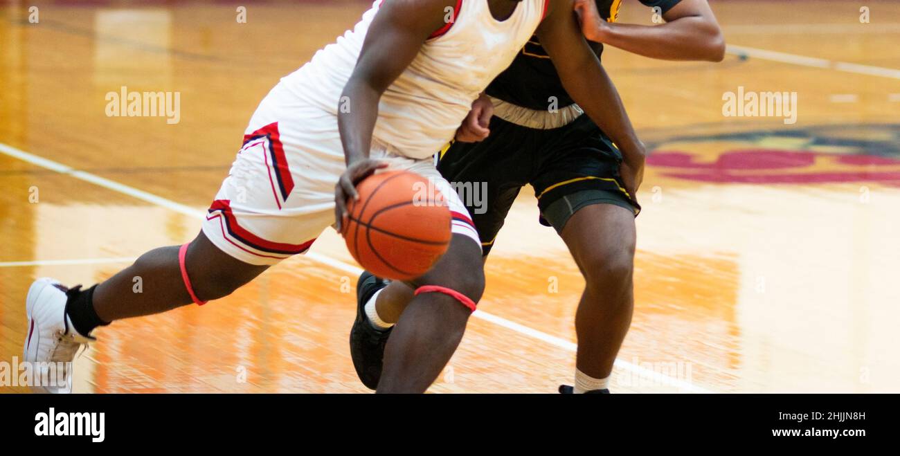 A high school basketball player has one step on his opponent as he id