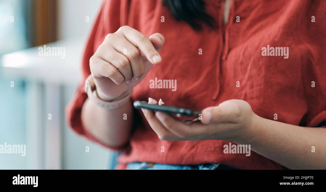 Close up woman using smart phone with hand finger touch screen, texting, chatting or social media Stock Photo