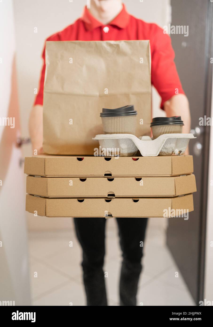 Closeup of pizza delivery, boxes of pizza and coffee in courier hands