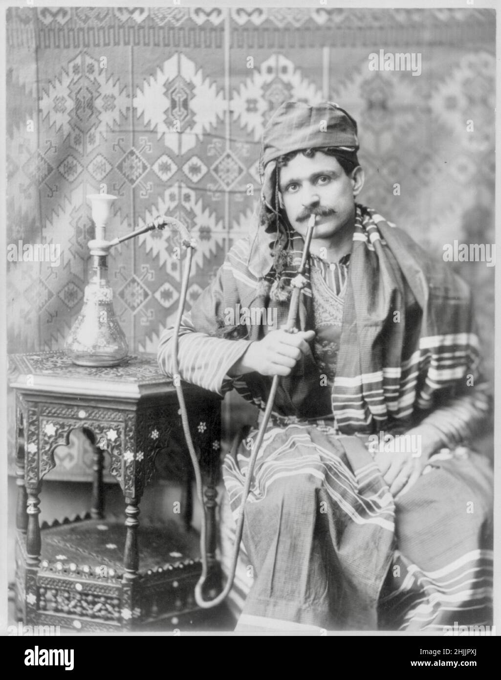 Man Smoking Water Pipe - 1901 Stock Photo
