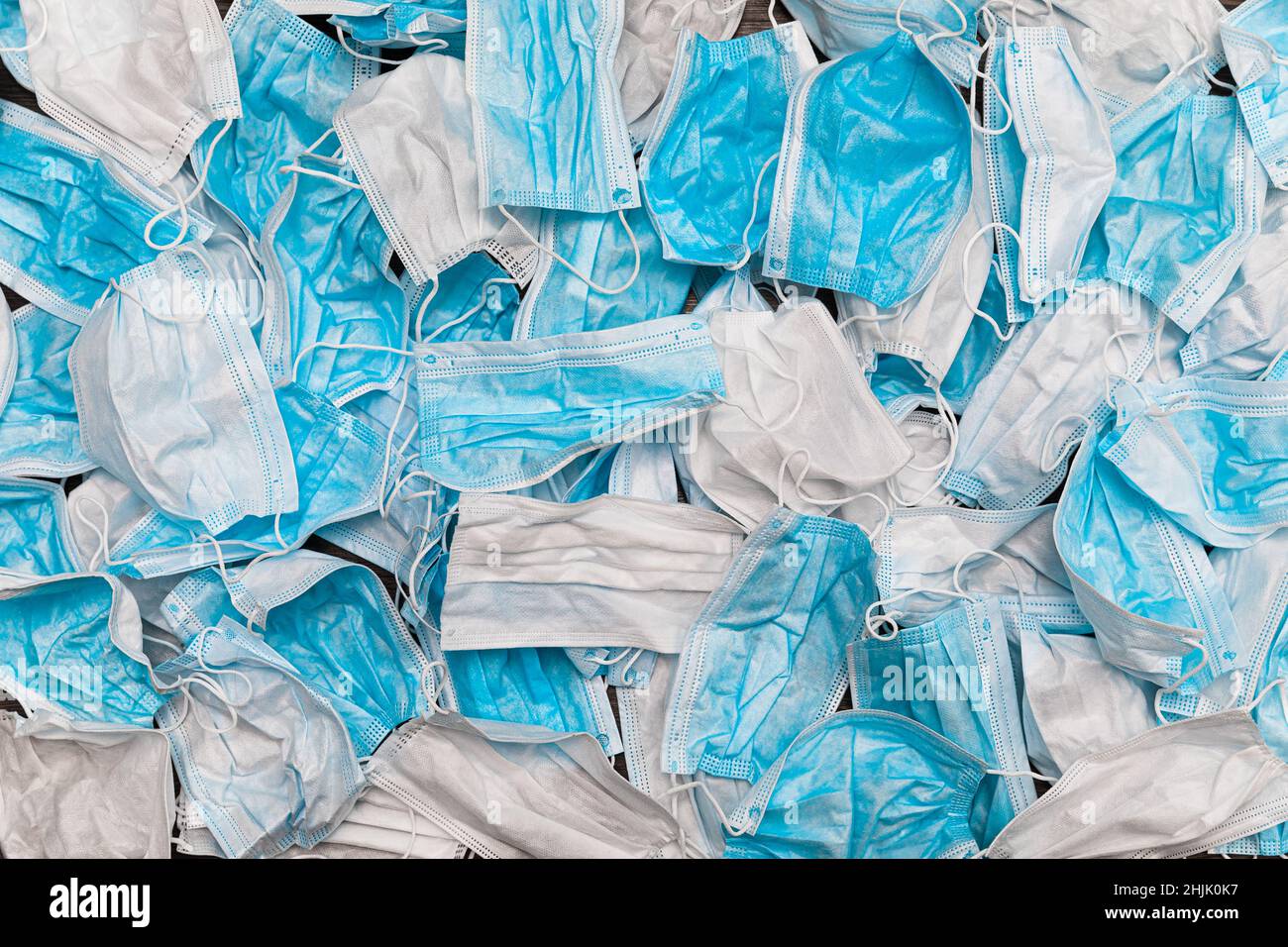 Used medical masks. Pile of used personal protective equipment PPE. Pollution surgical masks during coronavirus pandemic. Large number used medical Stock Photo