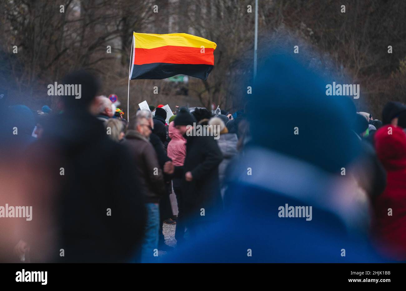 Nuremberg, Germany. 30th Jan, 2022. During the gathering under the slogan 'Denkpflicht statt Impfpflicht' at the Volksfestplatz, someone holds an upside-down German flag in his hands. According to police, at peak times 3500-4000 people took part in the protest action against state Corona measures. Credit: ---/dpa/Alamy Live News Stock Photo