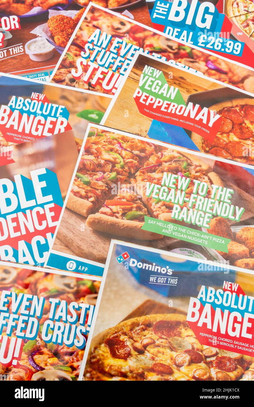 UK Domino's Pizza direct marketing leaflets from mailbox drop and featuring new menu additions. For UK Covid takeaway food ordering habits. Stock Photo